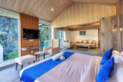a bedroom with a large bed and a living room at Kason Grand View Manali in Manāli