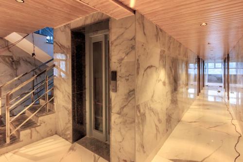 a room with a marble wall with a window at Kason Grand View Manali in Manāli