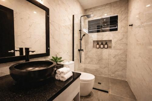 a bathroom with a black sink and a toilet at Solana Properties in Nadi
