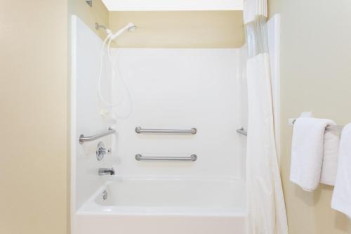a bathroom with a shower and a white tub at Days Inn By Wyndham Phenix City Near Fort Moore in Phenix City