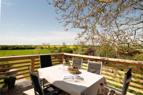 a table on a deck with a view of a field at Vadersdorf 31 Im Backhaus in Vadersdorf