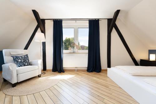 a bedroom with a bed and a chair and a window at Vadersdorf 31 Im Backhaus in Vadersdorf