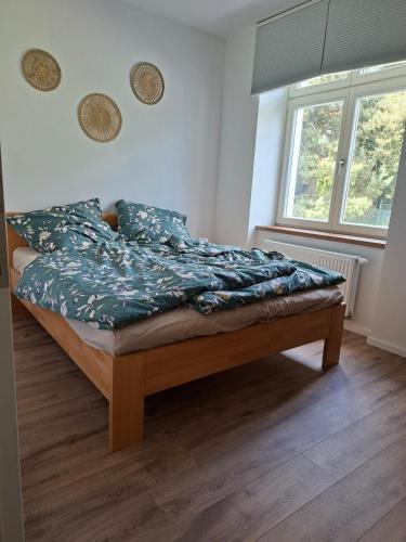 a bedroom with a bed with blue sheets and a window at Apartmá 575 in Strakonice