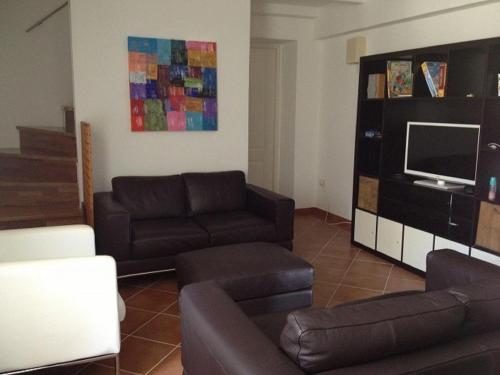 a living room with a couch and a tv at Appartamento Hortigia in Siracusa