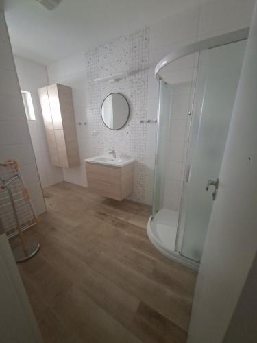 a white bathroom with a sink and a shower at Apartmá 575 in Strakonice