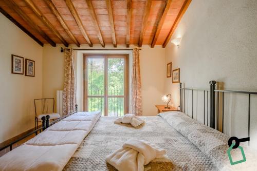 a bedroom with a large bed and a window at Hotiday Massa Marittima in Massa Marittima