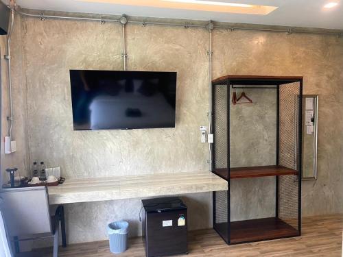 a shelf with a tv on a wall at Tree House Home Stay บ้านต้นไม้โฮมสเตย์อุทัยธานี in Uthai Thani