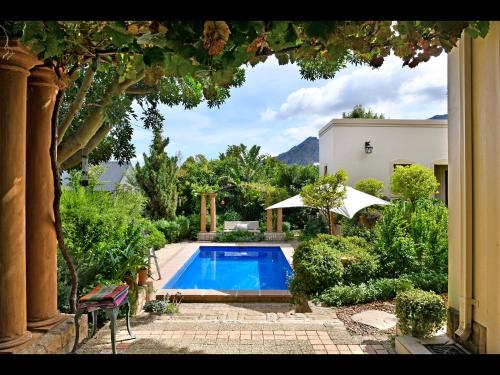 a house with a swimming pool in a yard at Petit Plaisir Cottage in Franschhoek