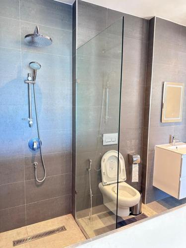 a bathroom with a shower with a toilet and a sink at Didas Villa Zanzibar in Zanzibar City