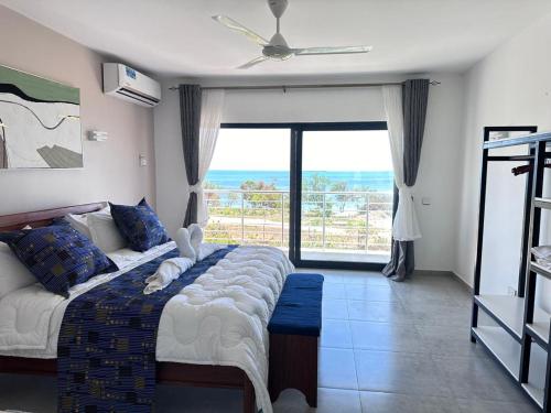 a bedroom with a bed with a view of the ocean at Didas Villa Zanzibar in Zanzibar City