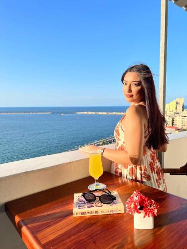 a woman sitting at a table with a drink at New Hyde Park House Hotel in Alexandria