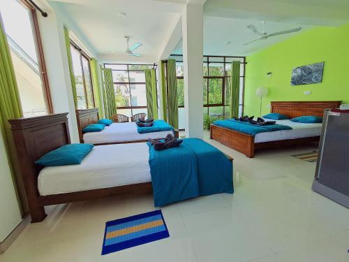 a bedroom with two beds with blue pillows at Jagabay Resort & Surfing School in Weligama