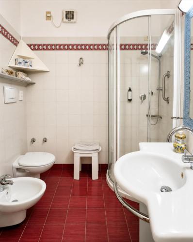 a bathroom with two sinks and a shower at Piccolo Hotel in Castiglione della Pescaia