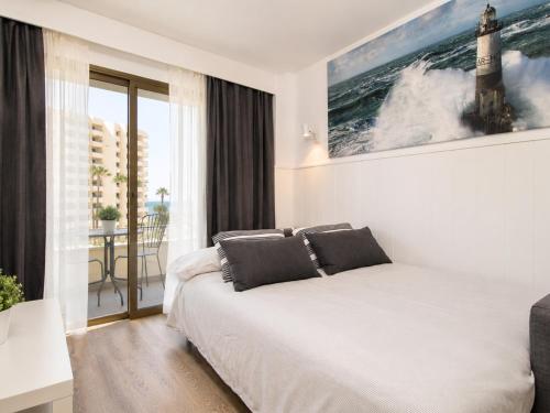 a bedroom with a bed with a painting on the wall at Ocean House Costa del Sol apartamentos varios by Costa del Sol Stay in Torremolinos