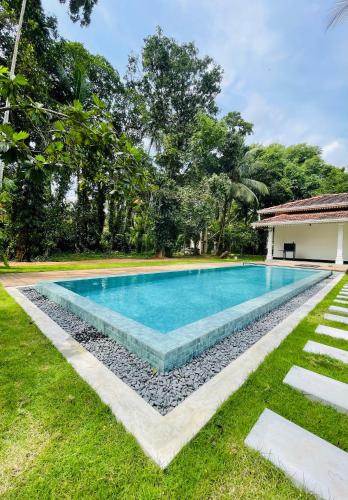 a swimming pool in the yard of a house at Wimala Sewana in Veyangoda