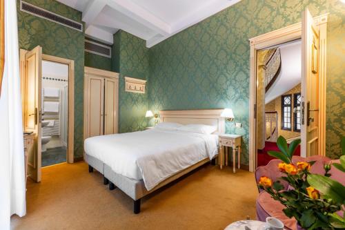 a bedroom with a white bed in a green room at Hotel Villa Delle Palme in Venice-Lido