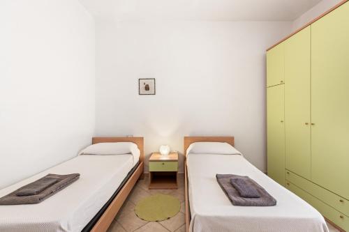 two beds in a room with green cabinets at Grande Casa Nel Villaggio in Scano Montiferro