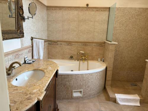 a bathroom with a tub and a sink and a bath tub at Angelo Doro Hotel in Ploieşti