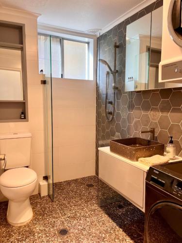 a bathroom with a toilet and a sink at Hello Bronte! in Sydney