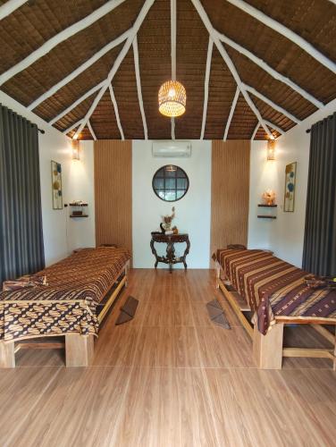 a room with two beds and a table in it at Ten RooMs in Telukbakau