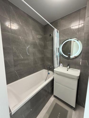 a bathroom with a tub and a sink and a mirror at Панорама in Borysxaw