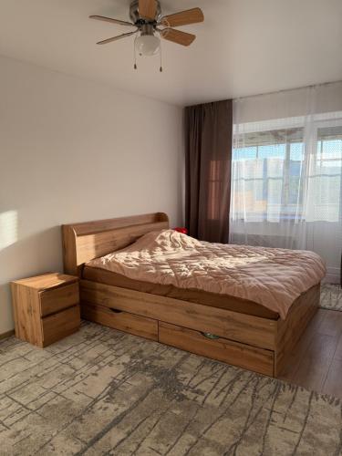a bedroom with a bed and a ceiling fan at Панорама in Borysxaw