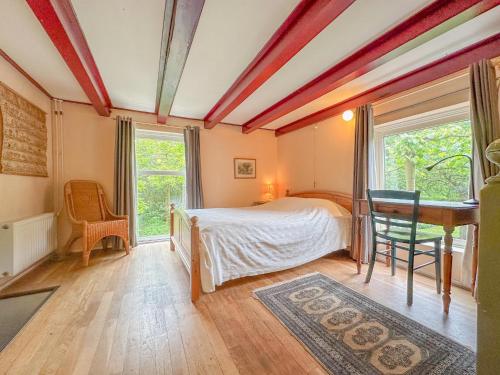 a bedroom with a bed and a desk and a window at Platschorre in Oudelande