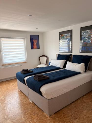 a bedroom with a large bed with blue sheets at Hermelsstübche in Siegen