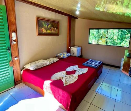 a bedroom with a large red bed in a room at Pousada Catuaí in Siqueira Campos