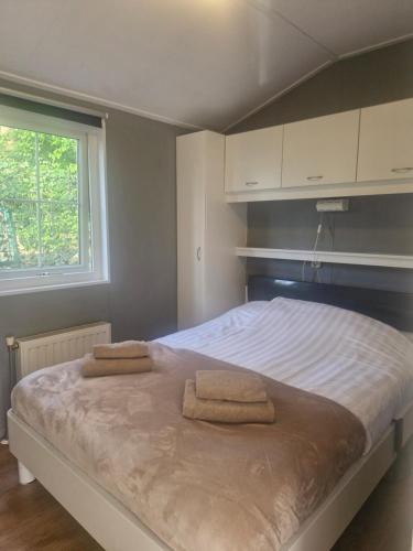 a bedroom with a bed with two towels on it at Chalet Vakantie Wageningen Veluwe in Wageningen