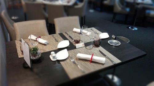 a table with napkins and wine glasses on it at Logis Au Grand Hotel et son restaurant in Mayenne