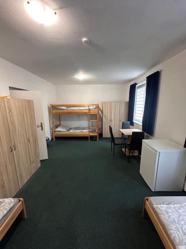 a room with two beds and a desk and a table at Ubytovna E75 in Mosty u Jablunkova