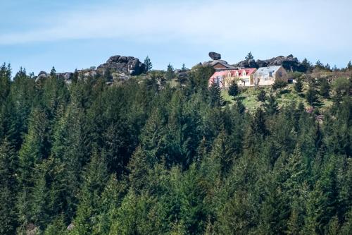 a house on top of a hill with trees at Casa das Penhas Douradas - Burel Expedition Hotel in Manteigas