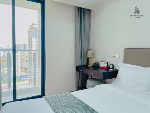 a hotel room with a bed and a window at Le Conde Maison in Phnom Penh