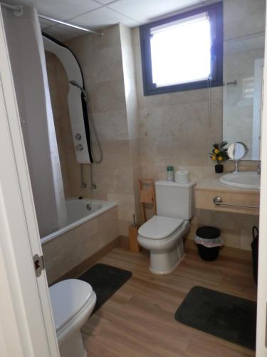 a bathroom with a toilet and a tub and a sink at Aloha Benidorm in Cala de Finestrat