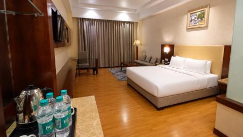 a hotel room with a bed and some water bottles at Golden Tulip Kukas Jaipur in Jaipur