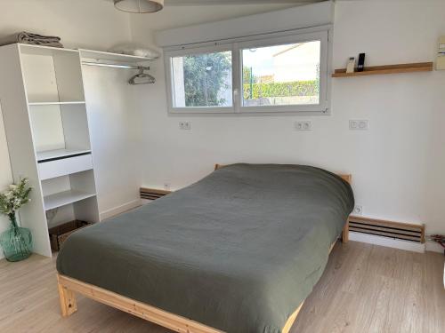 a bedroom with a bed and a window at Studio cosy avec accès jardin in Lunel-Viel