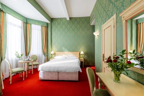 a hotel room with a bed and a table and chairs at Hotel Villa Delle Palme in Venice-Lido