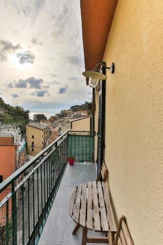 a wooden bench sitting on a balcony with a view at Affittacamere Dai Baracca in Riomaggiore