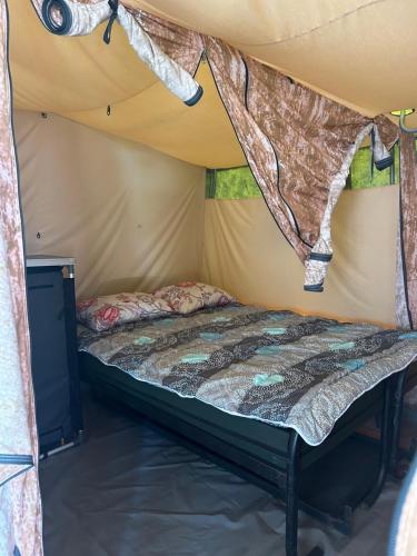 a bedroom with a bed in a tent at Camping De Meidoorn in Sluis