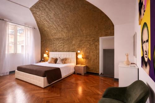 a bedroom with a large bed and a brick wall at Hotel Terme Neronensis in Pozzuoli
