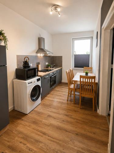 a kitchen with a washing machine and a table at Stilvolles Altbau-Apartment in zentraler Lage mit Workspace in Schwerin