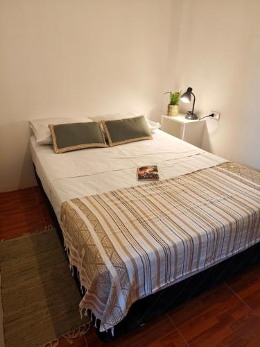 a large bed in a room with a lamp at La Casita de Kevin in Los Órganos