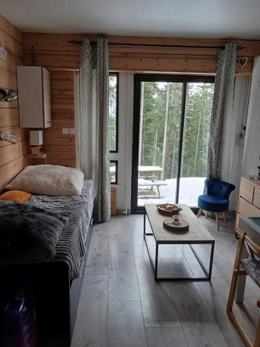 a bedroom with a bed and a table in a room at Studio rez de jardin Praloup in Uvernet