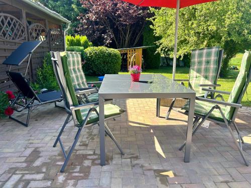a table with chairs and an umbrella on a patio at Kastanienidyll in Grabowhöfe