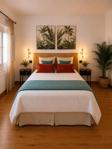 a bedroom with a large bed with red pillows at Hotel Temple Pradorrey in Astorga