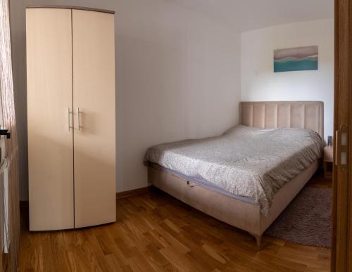 a bedroom with a bed and a cabinet at New Modern Apartments with Private Parking in Leštane