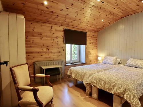 a bedroom with a bed and a chair and a window at Baronheid in Francorchamps