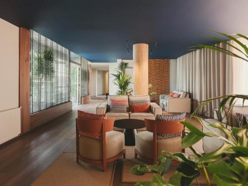 a lobby with a couch and chairs and a table at Hotel Mediterráneo in Roses