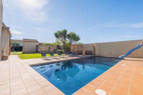 a swimming pool with chairs and a water slide at Cal Ferrer Nou Costa Brava in Riumors